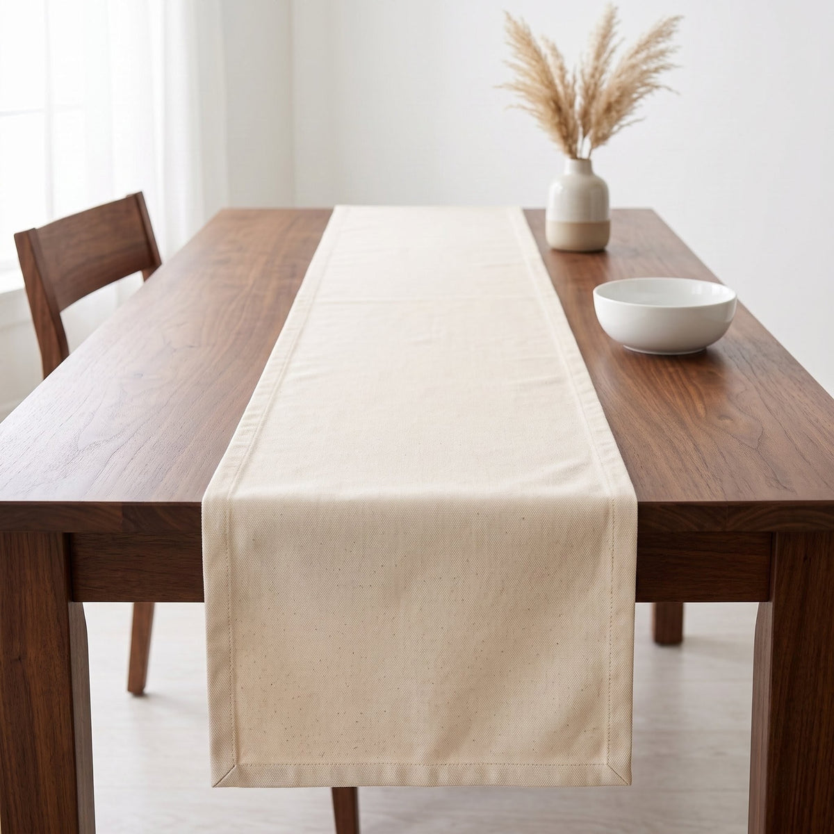 Camino de mesa de lona de algodón crudo sobre mesa de madera oscura, con jarrón de pampas y bowl blanco, decoración de comedor minimalista | Casaverde Artesanal